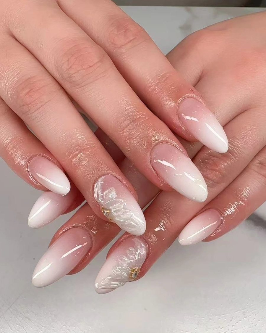 Soft nude and white ombre almond nails with fine linework